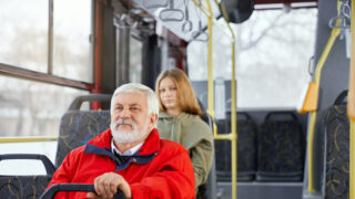 Älterer Herr sitzt in einem Bus